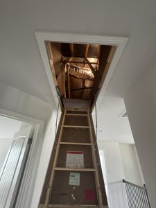 Pull-down attic stairs showing access to indoor HVAC equipment.