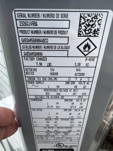 Outdoor HVAC equipment label showing model and serial number.